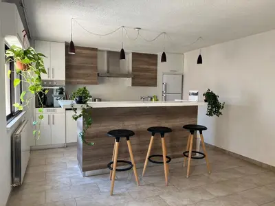 a kitchen with three bar stools at a counter at Newly refurbished 2-bedroom flat in a compound in Amman