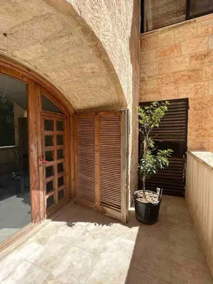 an entrance to a building with a door and a plant at Newly refurbished 2-bedroom flat in a compound in Amman