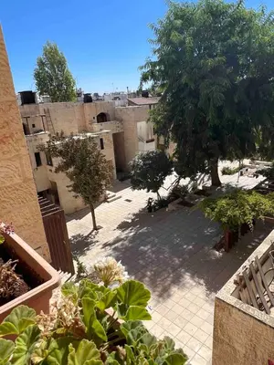a view of a courtyard with trees and buildings at Newly refurbished 2-bedroom flat in a compound in Amman