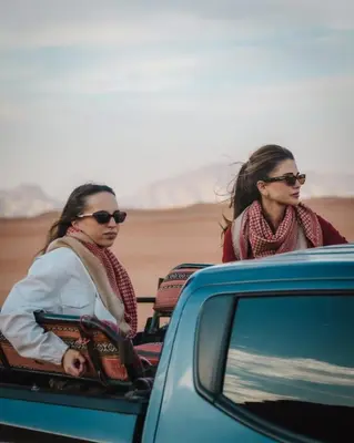 two women sitting in the back of a car at مخيم نجوم رم in Maḩaţţat Dīsah