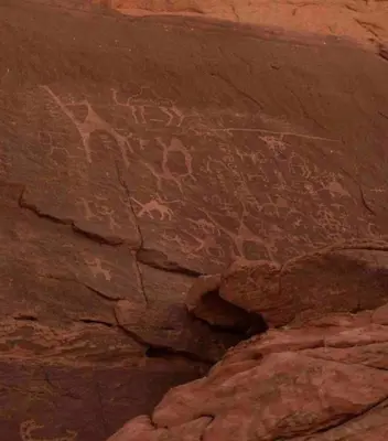 a rock wall with some writings on it at مخيم نجوم رم in Maḩaţţat Dīsah