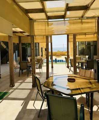 a patio with tables and chairs and a pool at Swemeh hills resort in Sowayma