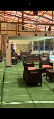 a patio with benches and a table and chairs at شاليهات تلال اشتفينا in Ajloun