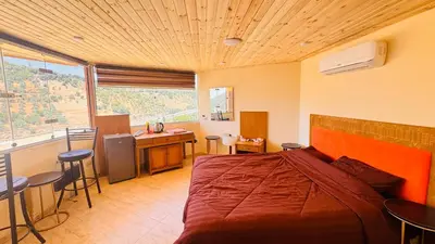 a bedroom with a bed and a table and chairs at عجلون - ajloun اشتفينا -9 in Ajloun