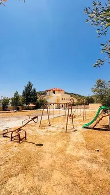 an empty playground with a swing set in a field at عجلون - ajloun اشتفينا -9 in Ajloun