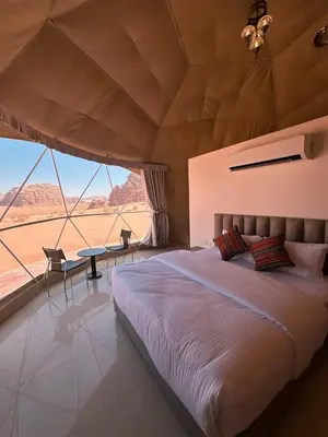 a bedroom with a large bed and a large window at Terra Nova Camp in Wadi Rum