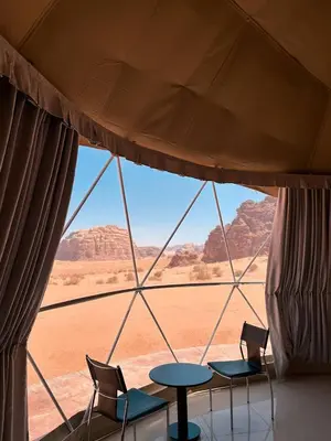a tent with chairs and a table and a view of the desert at Terra Nova Camp in Wadi Rum