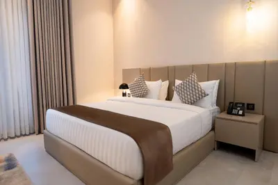 a bedroom with a large bed with white sheets and pillows at Golden Suites Hotel in Amman
