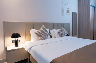 a bedroom with a large white bed with pillows at Golden Suites Hotel in Amman