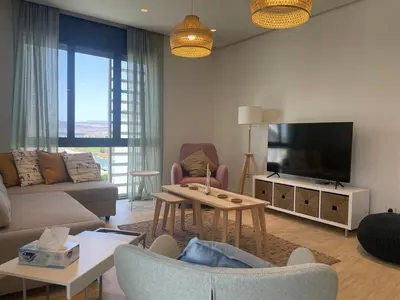 a living room with a couch and a tv at Brand new modern apartment in Ayla Golf residence in Aqaba