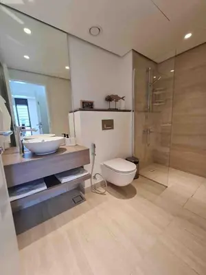a bathroom with a sink and a toilet and a shower at Brand new modern apartment in Ayla Golf residence in Aqaba