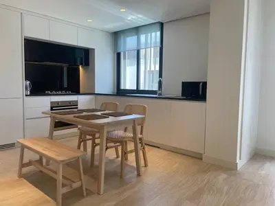 a kitchen with a table and chairs in a kitchen at Brand new modern apartment in Ayla Golf residence in Aqaba