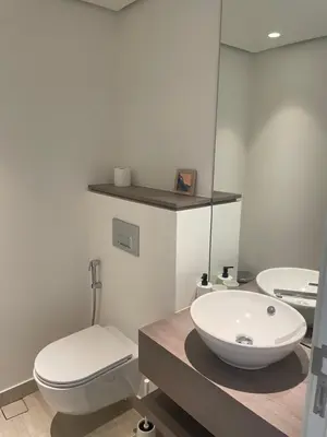 a bathroom with a white toilet and a sink at Brand new modern apartment in Ayla Golf residence in Aqaba