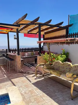 a patio with a bench and a table with a view at شاليه بانا جرش jerash