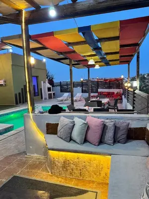 a bench with pillows on a patio with a pool at شاليه بانا جرش jerash