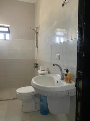 a white bathroom with a toilet and a sink at Murjan in Amman