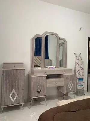 a bedroom with a wooden vanity and a mirror at Murjan in Amman
