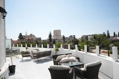 a patio with chairs and a table on a roof at Armada Avenue Hotel Amman in Amman