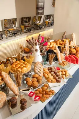 a table with various pastries and other foods on it at Armada Avenue Hotel Amman in Amman