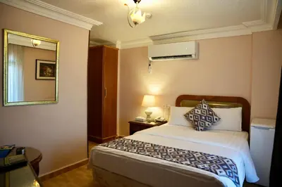 a hotel room with a bed and a mirror at Mass Plaza Hotel in Aqaba