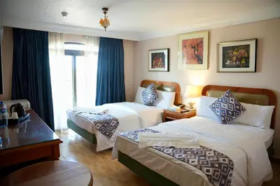a hotel room with two beds and a window at Mass Plaza Hotel in Aqaba