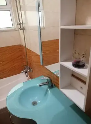 a bathroom with a blue sink and a shower at Humble house in Amman