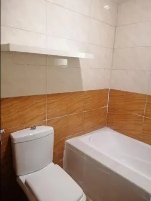 a bathroom with a white toilet and a bath tub at Humble house in Amman