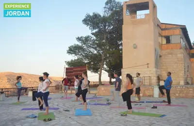 a group of people doing yoga in a courtyard at Tafila-Mataan in Al Jafr