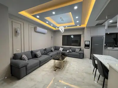a living room with a couch and a table at شقة واسعة مع ترس كبير in Amman