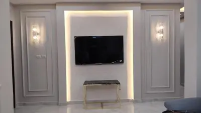 a living room with a television on a wall at شقة واسعة مع ترس كبير in Amman
