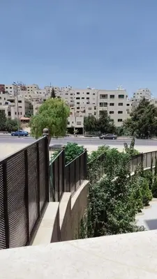 a balcony with a fence and a parking lot at شقة واسعة مع ترس كبير in Amman