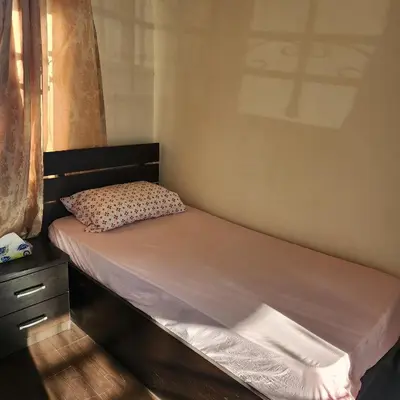 a small bed in a bedroom with a window at Eyad's Apartment in Amman