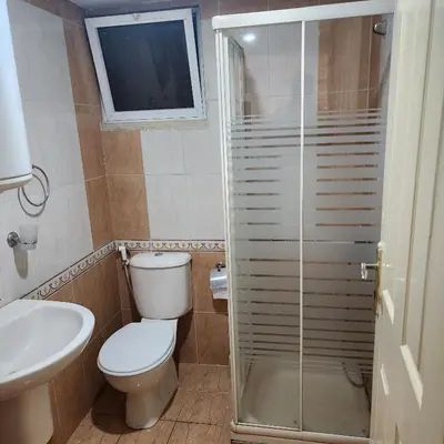a bathroom with a toilet and a glass shower at Eyad's Apartment in Amman