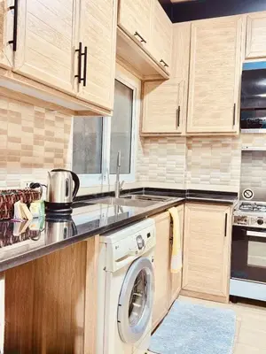 a kitchen with a washing machine and a sink at Modern Apartment in Prime Location - Jabal Amman in Amman