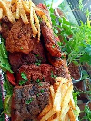 a plate of food with french fries and meat at يرموك هاوس in Aş Şarīḩ
