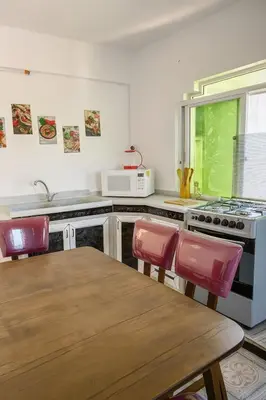 a kitchen with a table and chairs and a stove at Beit Ahlam Quiet Duplex Villa with Terrace and Scenic View near Umm Qais Ruins in Um Qeis