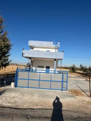 a shadow of a person standing in front of a gate at Beit Philodemus 2 in Um Qeis