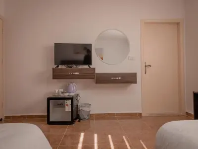 a room with a tv and a mirror on the wall at Petra Jewel Hotel in Wadi Musa