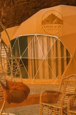 a tent with a table and chairs in front of it at Kinda Rum Luxury Camp in Wadi Rum