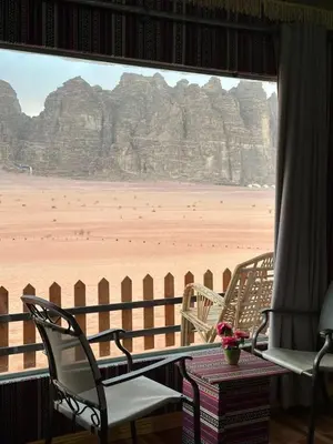 a room with chairs and a view of the desert at Kinda Rum Luxury Camp in Wadi Rum
