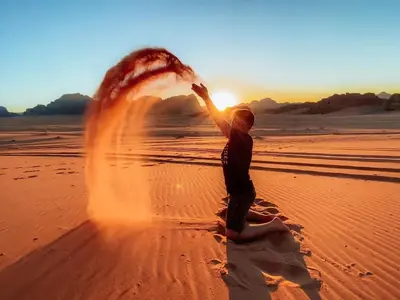 a person playing in the sand on the beach at Kinda Rum Luxury Camp in Wadi Rum