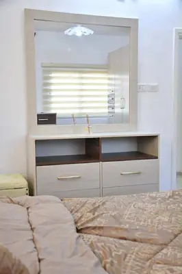 a bedroom with a bed and a dresser with a mirror at Furnished Apartment شقة مفروشة in Irbid
