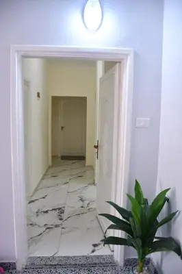 a hallway with a marble floor and a white door at Furnished Apartment شقة مفروشة in Irbid