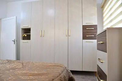 a bedroom with white cabinets and a bed at Furnished Apartment شقة مفروشة in Irbid