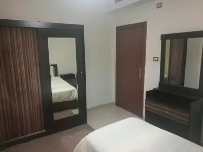 a bedroom with a mirror and a bed and a dresser at Family apartment in Abdoun Al Janobi in Amman