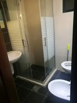 a bathroom with a glass shower and a sink at Family apartment in Abdoun Al Janobi in Amman