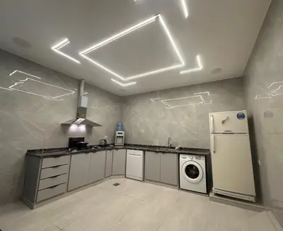 a kitchen with a refrigerator and a washer at Hassan villa in Sākib