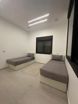 a bedroom with two beds and a flat screen tv at Hassan villa in Sākib