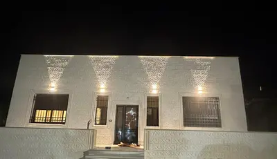 a white building with lights on it at night at Hassan villa in Sākib