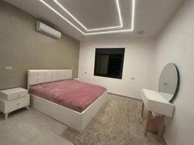 a bedroom with a bed and a sink and a mirror at Hassan